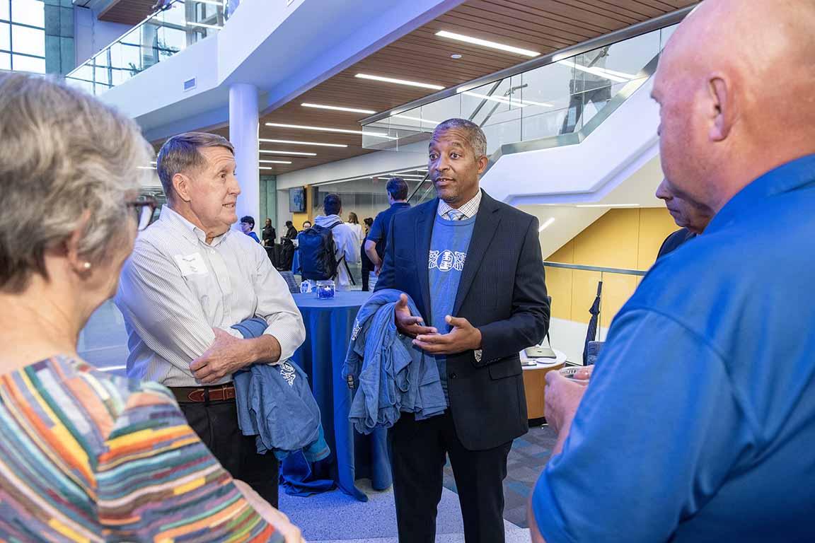 The dean of 博彩网址大全's School of Science and Engineering talks with attendees at an open house